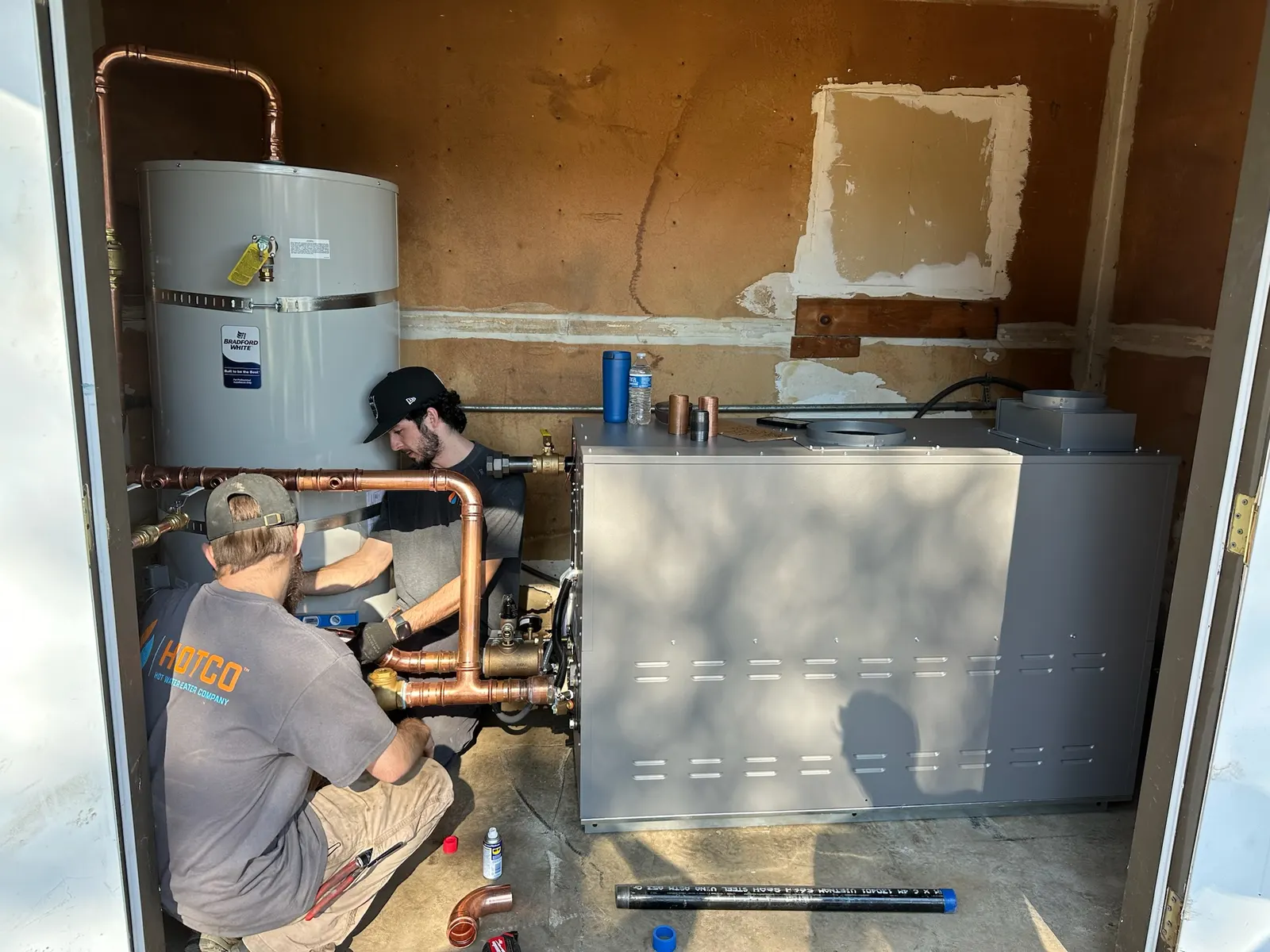 HOTCO technicians installing a commercial water heater for a business in the Sacramento region