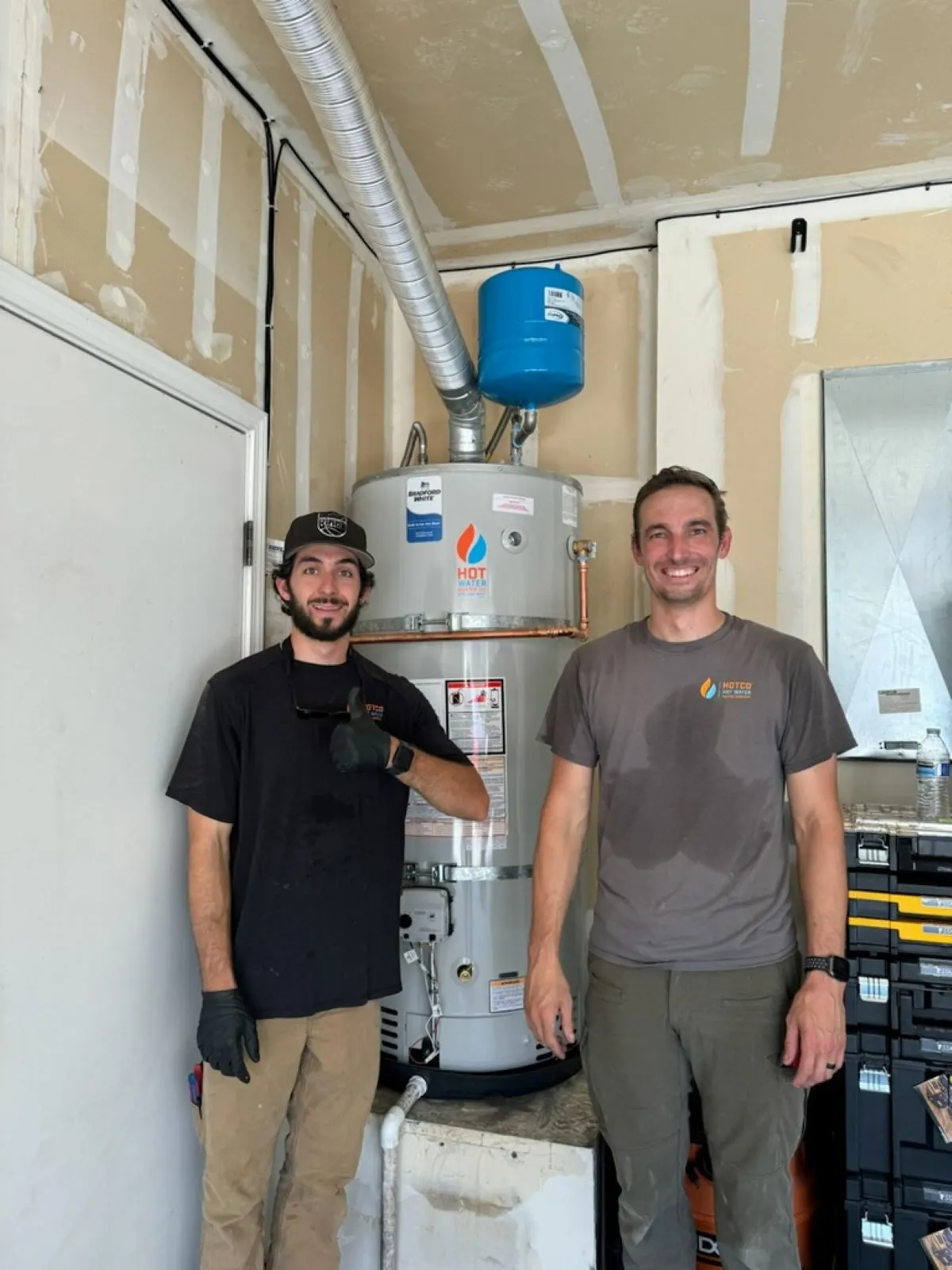HOTCO plumbers standing with a newly installed commercial gas water heater - Commercial Water Heaters