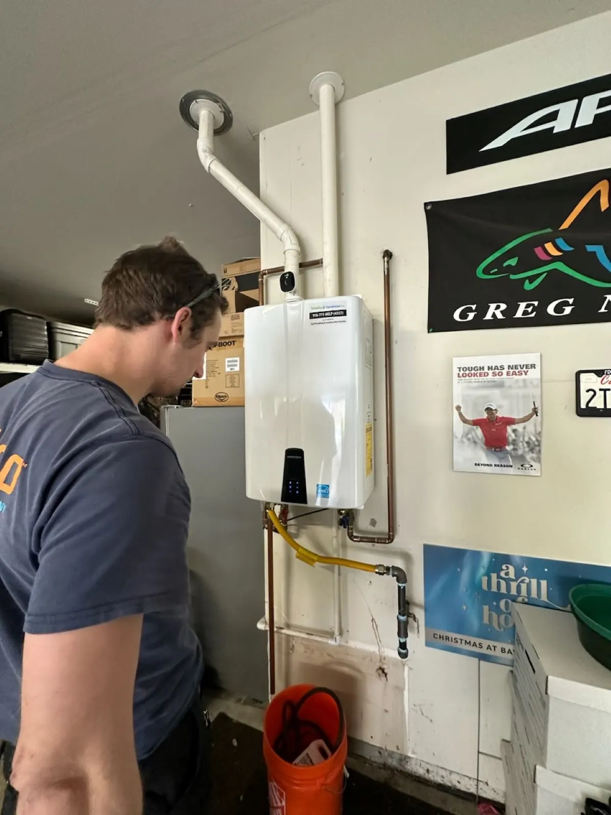 HOTCO technician next to a newly installed Navien tankless water heater - Navien Tankless Special