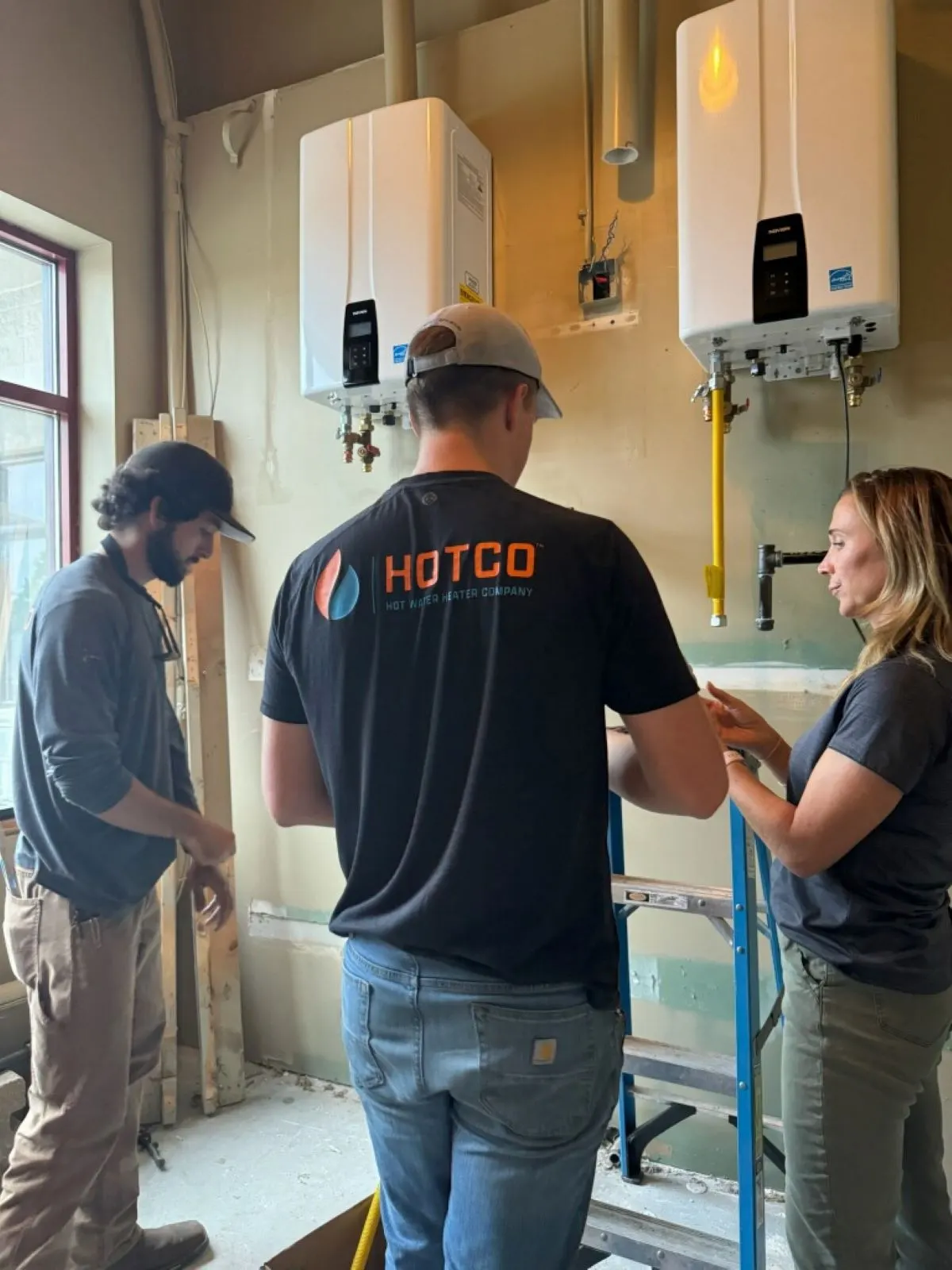 HOTCO technicians walking a homeowner through her new tankless water heater system - Water Heater Upgrades