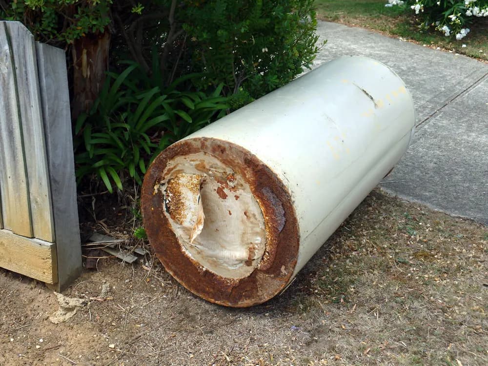 Old rusted water heater removed by HOTCO for haul-away and recycling - Haul-Away & Recycling